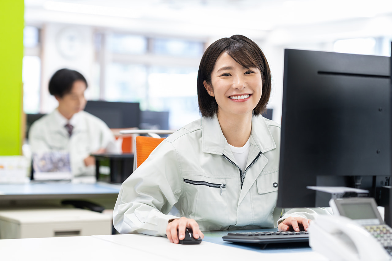 オフィスのPCの前で笑顔の女性